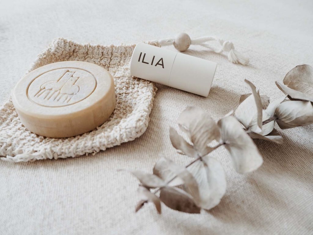 Eco-Friendly Travel Products displayed are a soap bar and a lipstick from Ilia 
